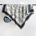 Detail eines eleganten Seidenschals mit Disteldruck und schwarz-weiß gestreiftem Rand - 90x90cm / Schwarz
