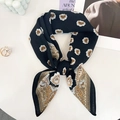 Detailopname van een zwarte zijden sjaal met paisley-motief en parelaccessoires - Zwart
