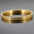Bracciale in acciaio inossidabile dorato con simboli mantra buddisti in rilievo su specchio scuro - Oro