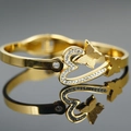 Bracciale rigido dorato con farfalla, cuore e strass luminosi con finitura lucida - Oro