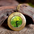 Macro view of vintage bronze tree of life locket with floral relief on wood background - Forest Green Background Style (XHXL0010)