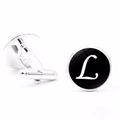 Close-up of silver-tone cufflinks featuring a polished black disk and white letter L detail - Letter L