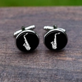 Detail of silver saxophone cufflinks with black face on a rustic wooden surface - Saxophone Style