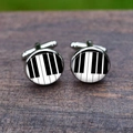 Detailed macro view of silver-tone cufflinks featuring a black and white piano key pattern - Piano Keys Style