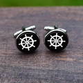 Close-up of nautical steering wheel cufflinks on a vintage wooden surface - Black Nautical Helm Style
