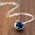 Macro d'un pendentif lune double face avec globe galaxie sur une surface en bois - Style Nébuleuse Profonde (ABXL1180-1)