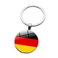 Close-up of a silver metal keychain featuring the German flag under a glass dome - Germany (ABXL1536)