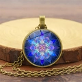 Dettaglio del ciondolo mandala in vetro su un supporto rustico in legno naturale - Bronzo