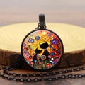Detail einer Halskette mit Katzen-Kunstanhänger, Volkskunst-Blumen und Sonne auf Holz - Schwarz
