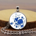 Detailed view of round glass pendant necklace featuring blue and white floral porcelain style - Blue Peony Style / Silver