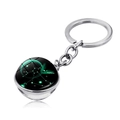 Detailed macro view of Sagittarius double-sided crystal ball keychain on white surface - Sagittarius