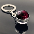 Macro shot of Virgo zodiac glass ball keychain with silver metal base and engraving - Virgo