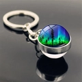 Macro detail of aurora borealis glass ball keychain with forest silhouette and silver ring - Aurora Style 7 (PSXL001176-7)