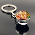 Macro shot of silver Gemini constellation keychain with artistic double-face glass pendant - Gemini