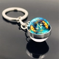 Macro shot of double-sided glass keychain featuring Pisces zodiac sign and koi fish design - Pisces