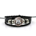 Vista macro del cabochon in vetro Route 66 su bracciale in pelle nera intrecciata - Stile Route 66 Nomi di Otto Stati (PSXL001195-2)