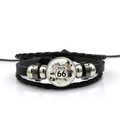 Detailed macro view of black leather bracelet featuring the vintage Route 66 glass dome charm - Vintage Distressed Route 66 Style (PSXL001195-11)