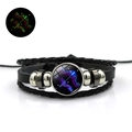 Detail van de Boogschutter leren armband met groen lichtgevend effect in het donker - Boogschutter