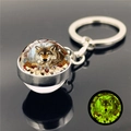 Detailed view of the luminous glass ball keychain showing the wolf pattern in the dark - Indian Feather Wolf Style 11 (XSWX2471-11)