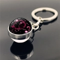Macro shot of Scorpio zodiac glass dome pendant on metal keychain over dark mirror surface - Scorpio (XSWX2268-12)