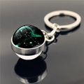 Close-up of Sagittarius constellation glass sphere keychain on a black reflective surface - Sagittarius (XSWX2268-8)