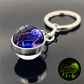 Luminous Aries constellation glass ball keychain with silver metal ring on reflective surface - Aries (XSWX2466-7-Aries)