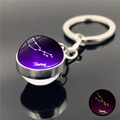 Macro detail of Taurus zodiac glowing crystal ball keychain with purple nebula - Taurus