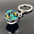 Macro view of double-sided Pisces zodiac glass ball keychain with silver metal base - Pisces