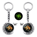 Luminous Taurus zodiac keychain with double-sided rotating moon pendant in dark green glow - Taurus