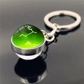 Macro detail of Leo zodiac crystal ball keychain featuring star map and silver alloy ring - Leo