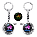 Détail d'un porte-clés Sagittaire rotatif avec pendentif lune lumineux et fini métal - Sagittaire