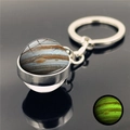 Detail of Jupiter sphere keychain with glow-in-the-dark effect on reflective black surface - Jupiter
