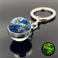 Detailed macro of Earth glass ball keychain with luminous green glow in dark feature - Earth