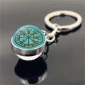 Close-up of Viking Vegvisir compass pendant keychain on black reflective surface - Lake Blue Background Compass Style (XSWX4422-9)