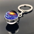 Vue macro d'un porte-clés boule de verre nébuleuse avec anneau argenté et reflet poli - Motif Nébuleuse Cœur d'Or (XSWX3423-11)