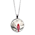 Detail of a silver-tone necklace with a cardinal bird printed on a round glass pendant - Cardinal in Snow (XSWX5042-4)