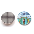 Macro view of 30mm Christmas glass fridge magnet showing festive patterns and magnetic back - Christmas House Scene (BXT2210-30mm)