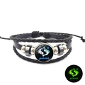 Detailopname van de zwarte leren Vissen-armband met een lichtgevende sterrenbeeld-bedel - Vissen