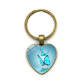 Detalle de llavero de corazón en bronce con mariposas azules bajo cúpula de vidrio - Tres Mariposas Azules Patrón Volador Marco Bronce Antiguo (XSWX5582-3)