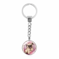 Close-up of a silver round keychain featuring a cute pug illustration with pink flowers - Pug Illustration With Pink Bow (XSWX5756-6)