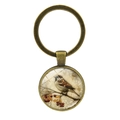 Vintage bronze keychain with round glass pendant featuring bird on branch illustration - Antique Bronze