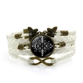 Detalle de pulsera tejida multicapa con símbolo místico, signo de infinito y dije de mariposa - Blanco