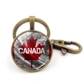 Detail of vintage bronze keychain featuring a red Canada maple leaf and lobster clasp - Brick Wall Texture Logo Style (XSWX8420-11) / Antique Bronze