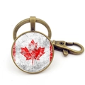 Detailed close-up of Canada flag keychain with antique bronze lobster clasp and round glass - Worn Distressed Vintage Maple Style (XSWX8420-8) / Antique Bronze