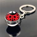 Macro shot of 45-degree angle ladybug glass ball keychain with silver metal base - Artistic Ladybug Design (XSWX4018-7)