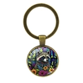 Antieke bronzen sleutelhanger met ronde glazen cabochon, kleurrijk wasbeer- en bloemmotief - Wasbeer / Antiek Brons