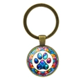 Detail of vintage bronze keychain featuring a colorful cat paw print under glass dome - Kaleidoscope Paw (XSWX8206-5)