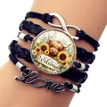Detailaufnahme des mehrlagigen Armbands mit Highland-Kuh und Love-Anhängern am Handgelenk - Welcome Hochlandrind Stil (XSWX7595-7)
