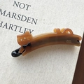 Detail of handmade acetate cat hair clip with bow decoration and France engraving - Caramel