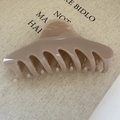 Dettaglio del grande fermaglio per capelli color caffè su tessuto beige, finitura lucida - Stile Farfallina Chiusura / Caffellatte